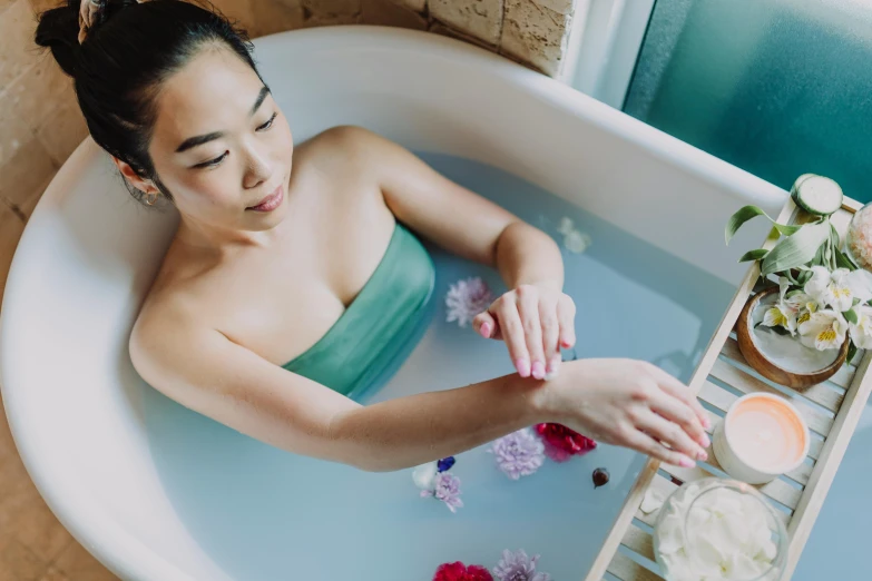 a woman in a bathtub with candles and flowers, unsplash, chinese woman, fan favorite, aquamarine, natural hands and arms