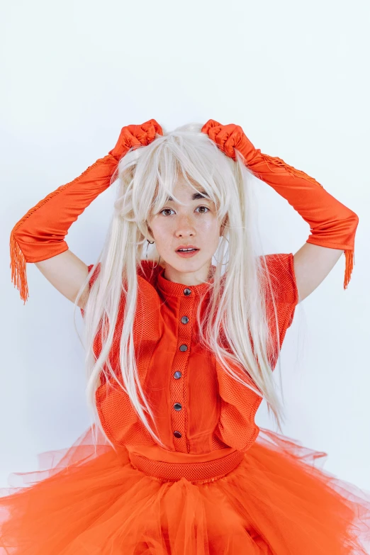 a woman in an orange dress posing for a picture, an album cover, inspired by Luma Rouge, white fringy hair, nishihara isao, catalog photo, wearing ragged clothing