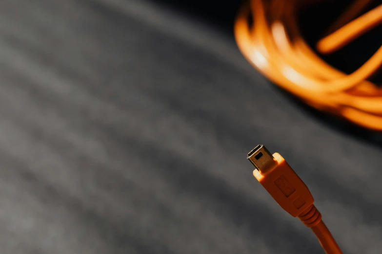 a close up of a usb cable on a table, by Thomas Häfner, unsplash, graffiti, coloured in orange fire, fire & smoke, photographed for reuters, bottom angle