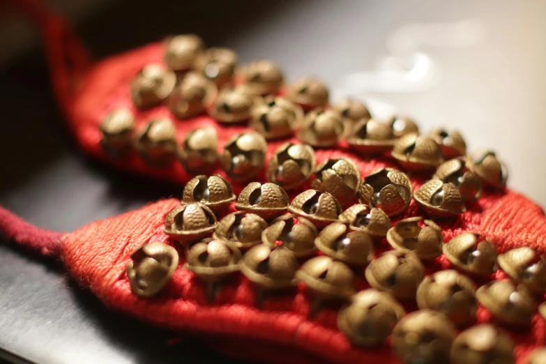 a bunch of bells sitting on top of a red cloth, wearing studded leather, pochi iida, up close, slide show