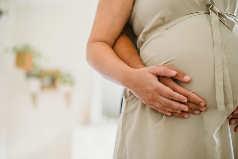 a pregnant woman with her hands on her belly, pexels contest winner, holding each other, manuka, sympathetic, very consistent