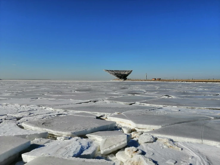 a boat sitting on top of a frozen lake, inspired by Zha Shibiao, pexels contest winner, land art, radio telescope, joel sternfeld, seaview, three - quarter view