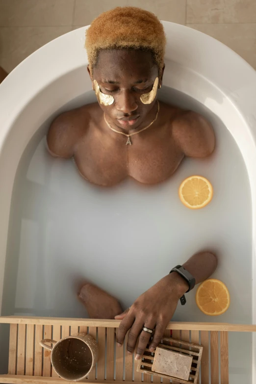 a man that is sitting in a bath tub, by Jessie Alexandra Dick, trending on pexels, renaissance, lemons, man is with black skin, healing pods, he is a long boi ”