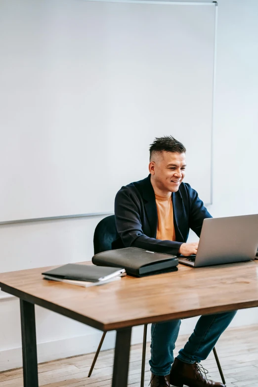 a man sitting at a table with a laptop, damien tran, standing in class, centralised, lgbtq