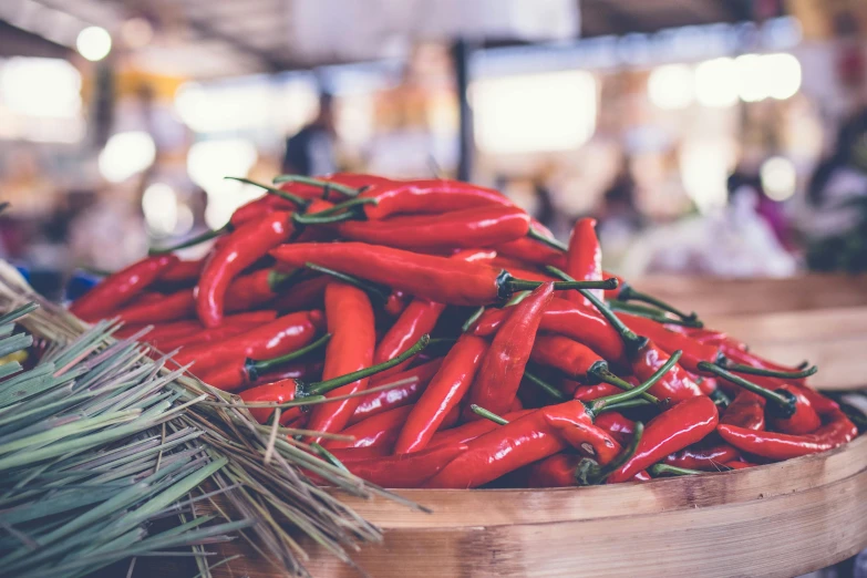 a wooden bowl filled with red hot peppers, pexels contest winner, market stalls, background image, instagram post, retro stylised