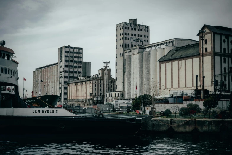 a boat that is sitting in the water, pexels contest winner, brutalism, silo, port scene background, high grain, low quality photo