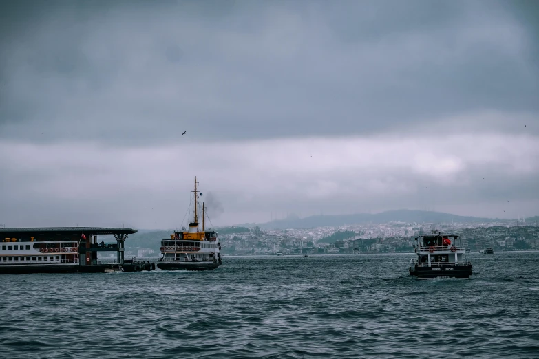 a couple of boats that are in the water, pexels contest winner, hurufiyya, grey skies rain, turkish and russian, thumbnail, 1 2 9 7