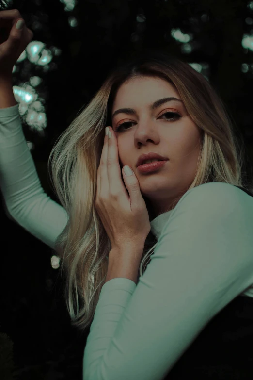 a woman holding a cell phone up to her face, inspired by Elsa Bleda, trending on pexels, renaissance, beautiful blonde hair, haze over the shoulder shot, still from a music video, waist high