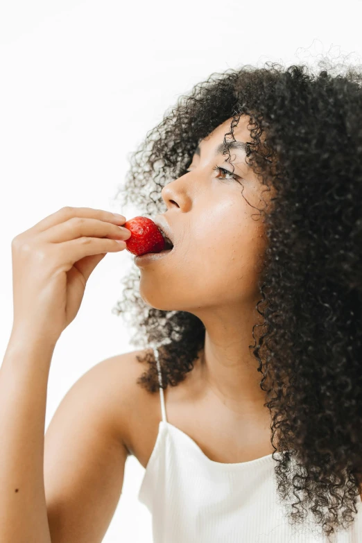 a woman with curly hair eating a strawberry, trending on pexels, cutout, mixed-race woman, digital image, gif