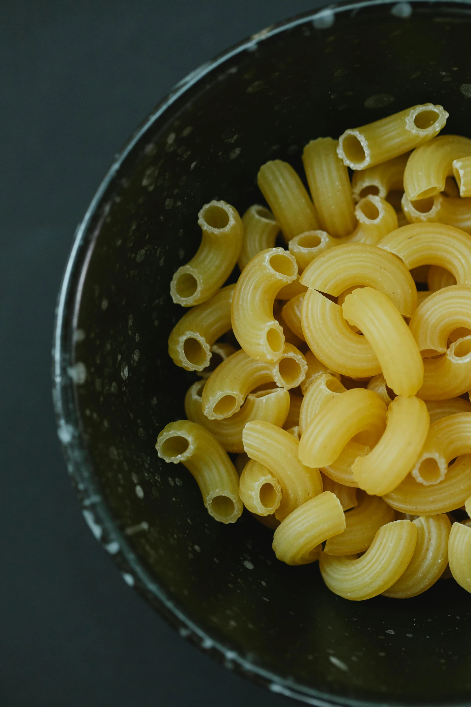 a bowl filled with pasta sitting on top of a table, a picture, curled slightly at the ends, larvae, on a black background, uncrop