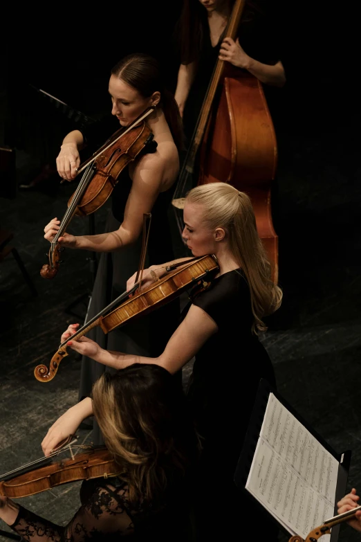 a group of women playing musical instruments on a stage, standing on top of a violin, half image, square, thumbnail