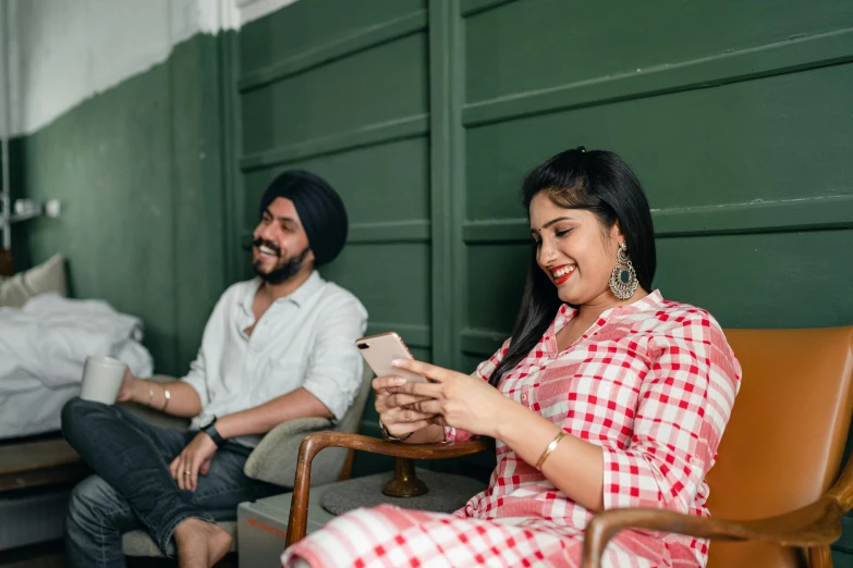 a man and a woman sitting next to each other, by Manjit Bawa, trending on pexels, happening, she is holding a smartphone, avatar image, sitting in a lounge, roaming entertainers