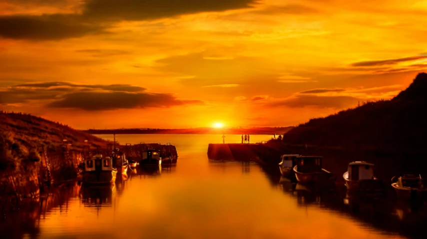 a group of boats sitting on top of a body of water, by Brian Thomas, pexels contest winner, romanticism, golden glow, thumbnail, harbour, vibrant sunset