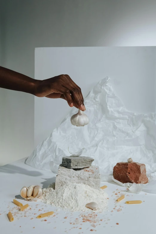 a person holding an egg over a pile of food, a marble sculpture, by Lily Delissa Joseph, white powder bricks, studio product shot, chiseled formations, a still of an ethereal