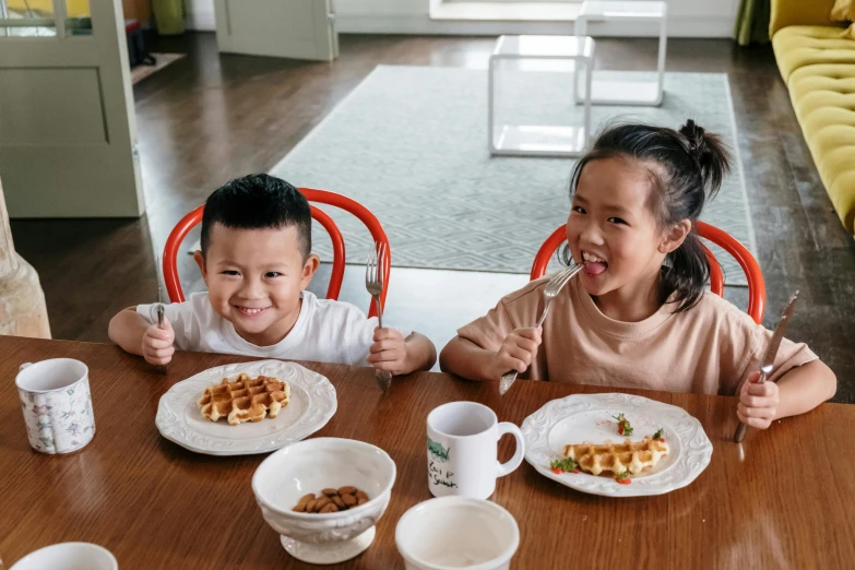 a couple of kids sitting at a table with plates of food, by Nicolette Macnamara, pexels contest winner, hurufiyya, deconstructed waffle, joy ang, manuka, youtube thumbnail