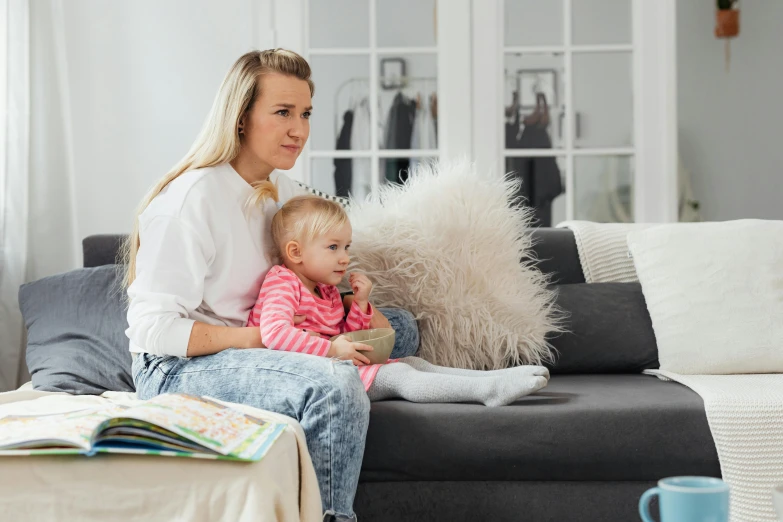 a woman sitting on a couch holding a child, a cartoon, by Adam Marczyński, pexels contest winner, watching tv, straya, confident looking, profile image