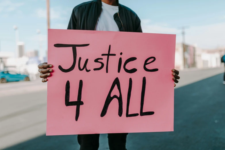 a person holding a sign that says justice 4 all, trending on pexels, diverse, instagram post, ad image, brown