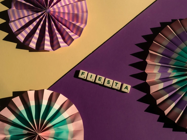 a couple of paper flowers sitting on top of a table, an album cover, by Gina Pellón, trending on unsplash, kinetic art, purple checkerboard, folklorico, geometric backdrop; led, letters