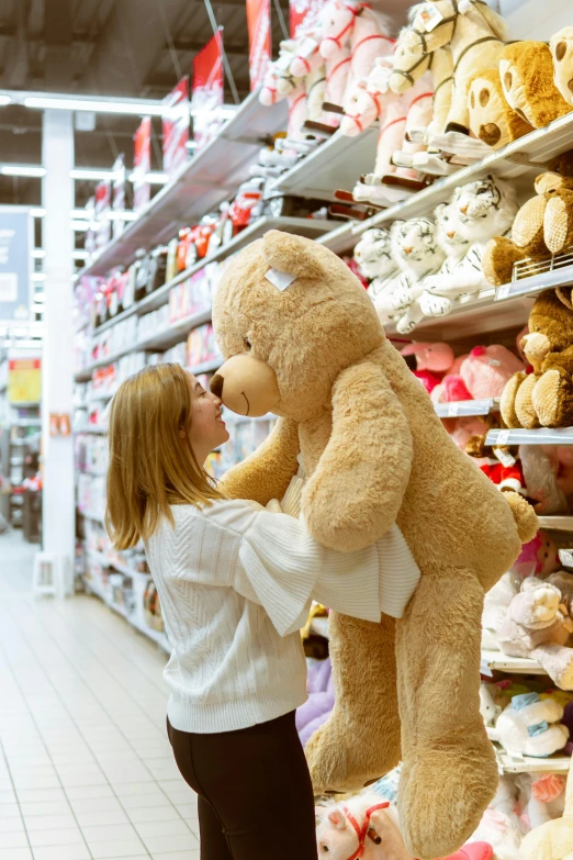 a woman holding a giant teddy bear in a store, pexels contest winner, inspect in inventory image, in love, goldilocks, toy commercial photo