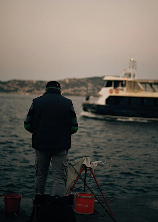 a man standing next to a boat on a body of water, art photography, istanbul, cinematic footage, behind the scenes photo, worksafe. cinematic