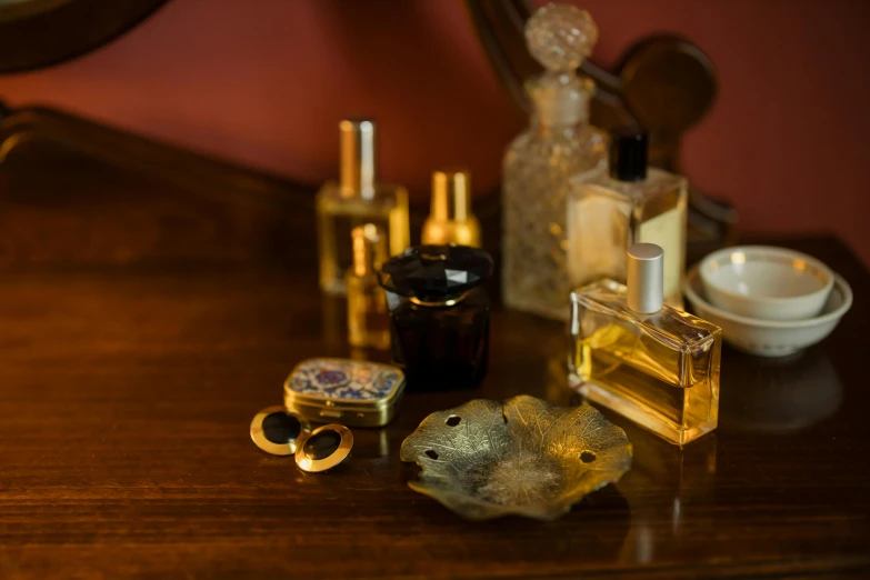 a table topped with perfume bottles on top of a wooden table, inspired by Alexandre Cabanel, unsplash, renaissance, brass plated, decollete, brown, nightcap