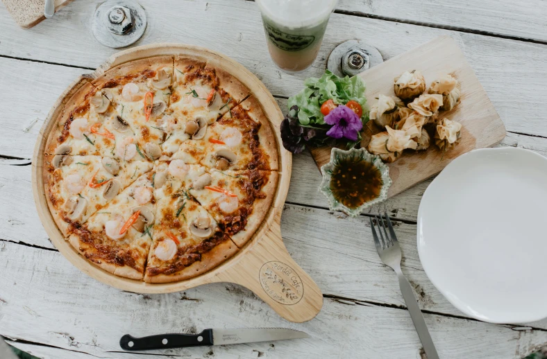 a pizza sitting on top of a wooden cutting board, offering a plate of food, on a white table, 3 mary's, blond