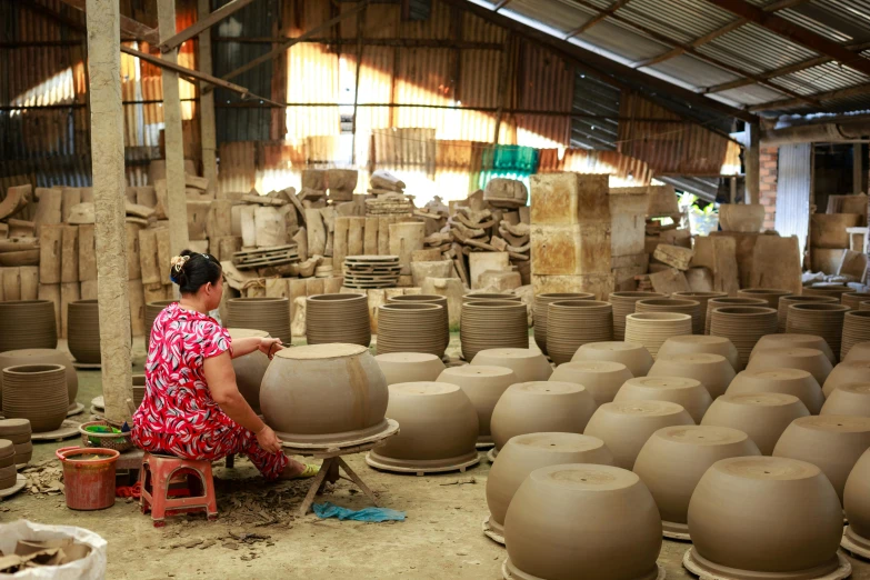 a woman sitting in front of a pile of clay pots, huge factories, avatar image, mai anh tran, thumbnail