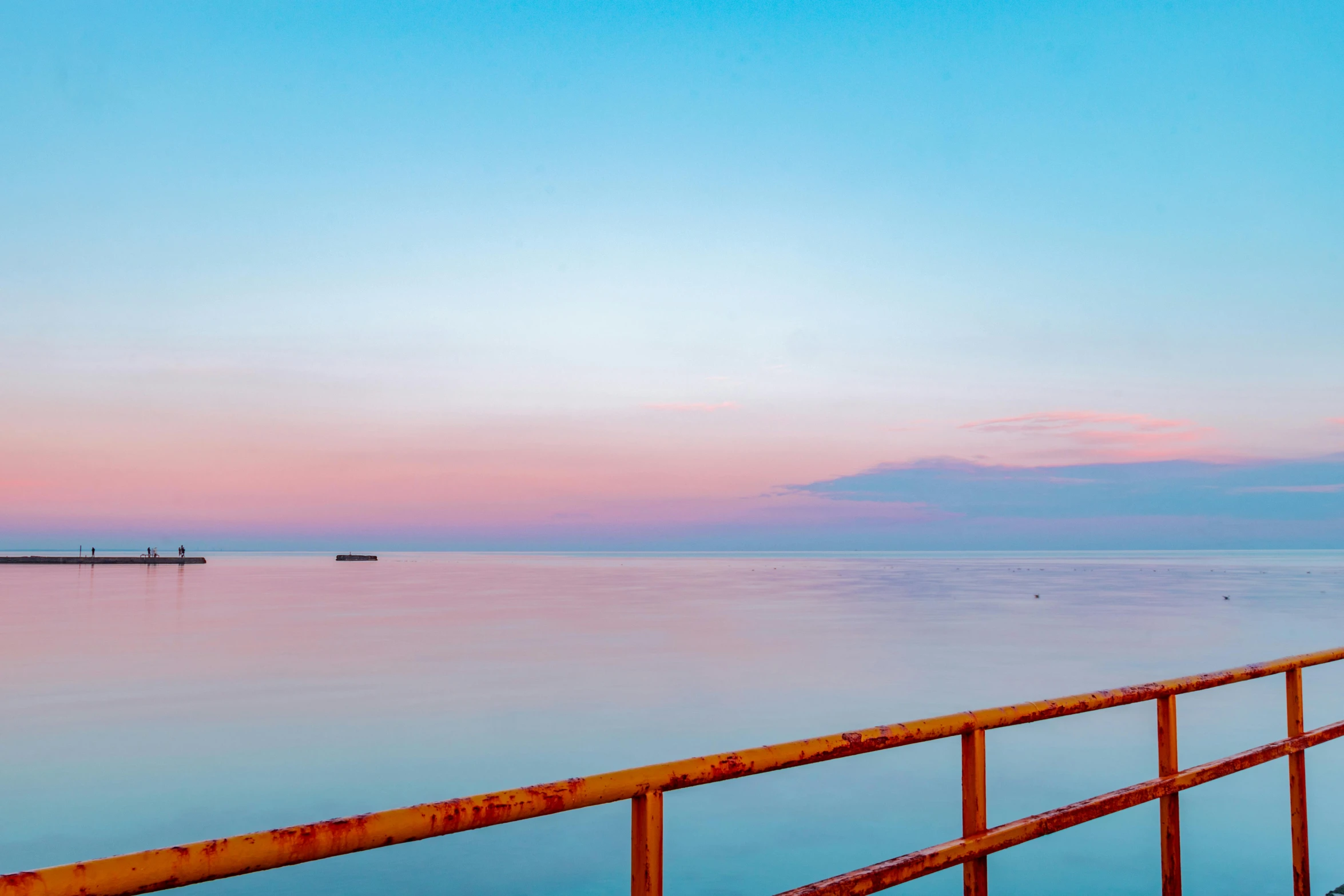 a bench sitting on top of a pier next to a body of water, by Carey Morris, pexels contest winner, romanticism, pink and blue gradients, looking onto the horizon, ukraine. photography, calm evening