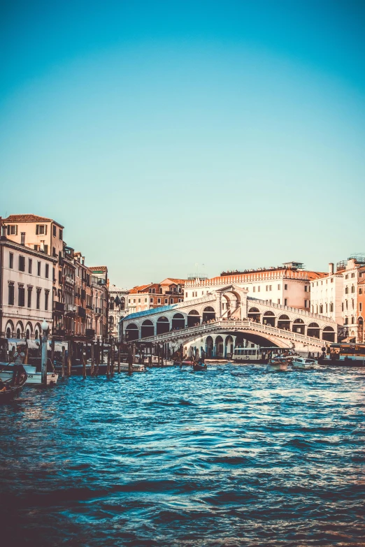a bridge that is over a body of water, inspired by Quirizio di Giovanni da Murano, pexels contest winner, renaissance, rococo architecture, floating buildings, clear blue skies, retro style ”