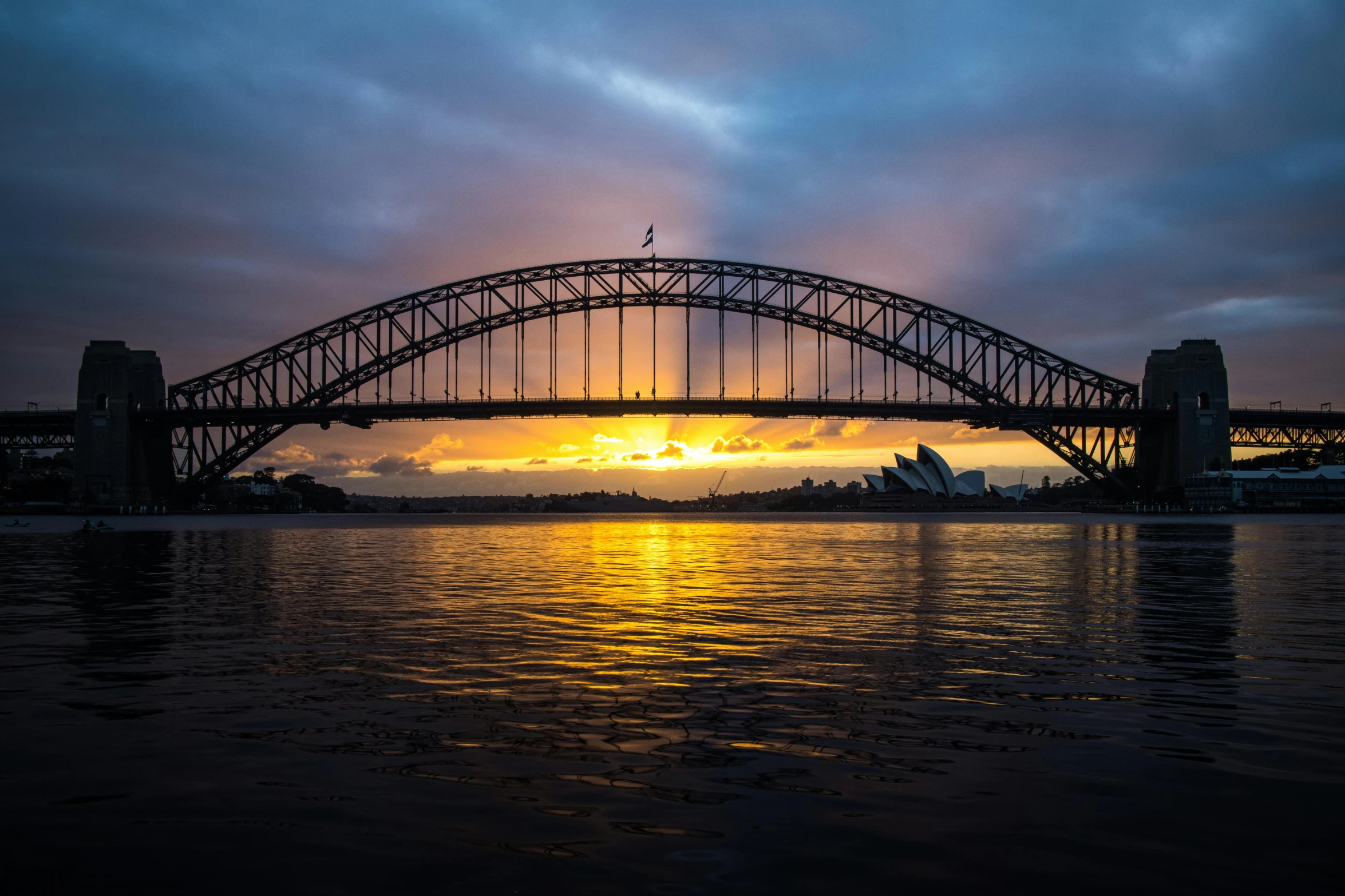 a bridge over a body of water under a cloudy sky, a picture, inspired by Sydney Carline, pexels contest winner, sun at dawn, massive arch, harbour, high quality photo