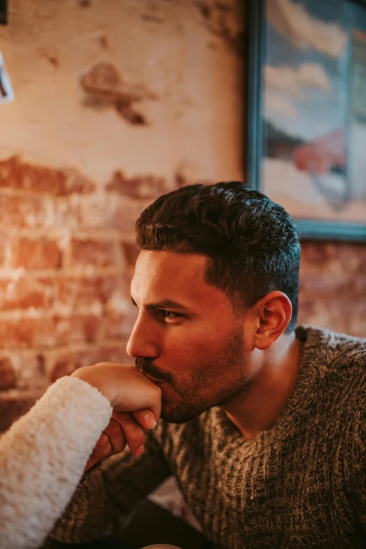 a man sitting in front of a laptop computer, a photo, trending on pexels, romanticism, in a pub, portrait of two people, he is wearing a brown sweater, sam nassour