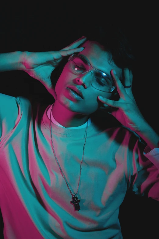 a man standing in front of a black background, an album cover, by Robbie Trevino, trending on pexels, aestheticism, beautiful androgynous girl, with square glasses, pink and blue lighting, ariel perez