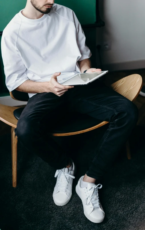 a man sitting in a chair reading a book, pexels contest winner, office clothes, dressed in a white t shirt, ready for a meeting, outfit photo