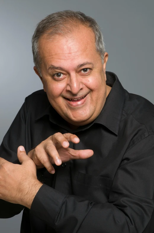 a man in a black shirt posing for a picture, inspired by Samuel Silva, bending down slightly, shrugging arms, farid ghanbari, promotional image