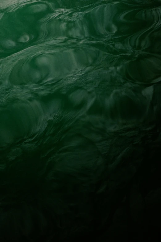 a close up of the surface of a body of water, dark green tint, lovecraftian background, splash image, an ai generated image