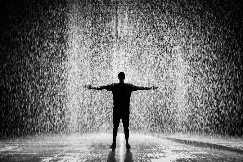 a man standing in the rain with his arms outstretched, a black and white photo, by Daniel Gelon, pexels contest winner, conceptual art, sculpture made of water, ryoji, ffffound, drake