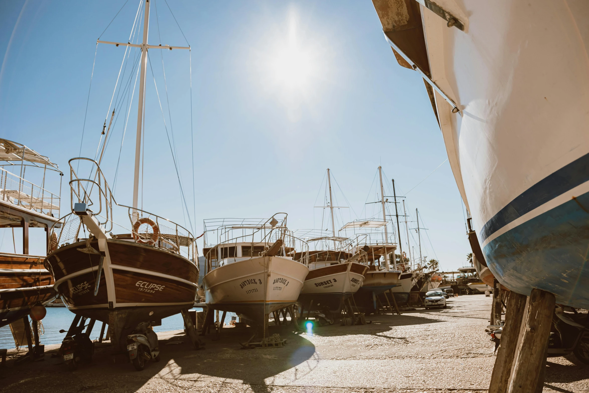 a group of boats sitting on top of a sandy beach, in the sun, shipyard, unsplash photo contest winner, turkey