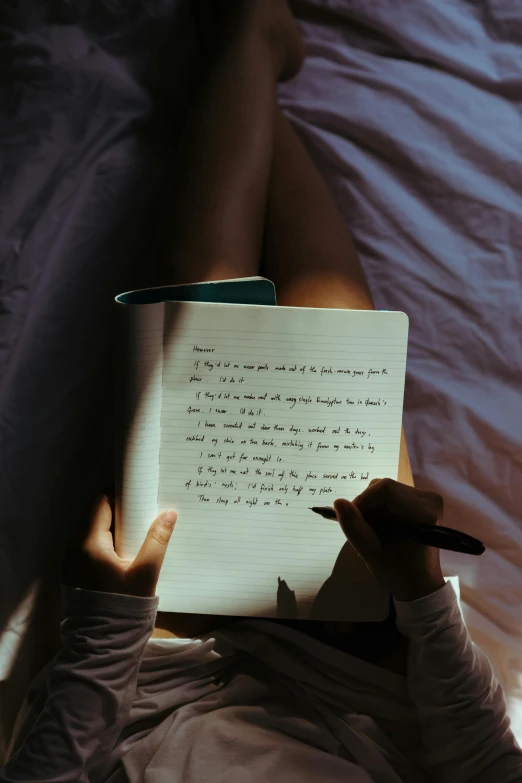 a person laying in bed reading a book, by Robbie Trevino, pexels contest winner, with some hand written letters, notebook, low key, ballpoint
