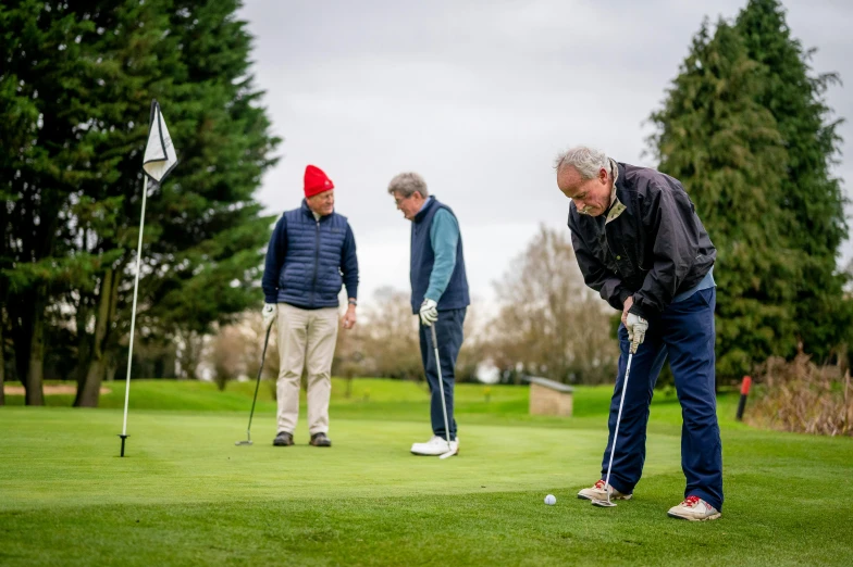 a group of men playing a game of golf, a portrait, by Julian Hatton, unsplash, 7 0 years old, 3 heads, low vantage point, head down