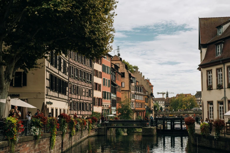 a river running through a city next to tall buildings, pexels contest winner, renaissance, french village exterior, 🦩🪐🐞👩🏻🦳, mill, muted colors. ue 5