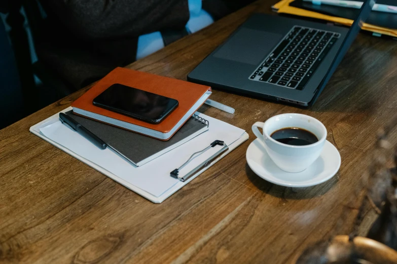 a laptop computer sitting on top of a wooden table next to a cup of coffee, trending on pexels, character sheets on table, thumbnail, background image, taken on iphone 14 pro