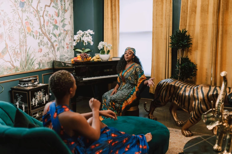 a woman sitting in a living room next to a zebra, an album cover, by Julia Pishtar, pexels contest winner, black arts movement, wearing dark green robes, two women, gold and teal color scheme, performing a music video