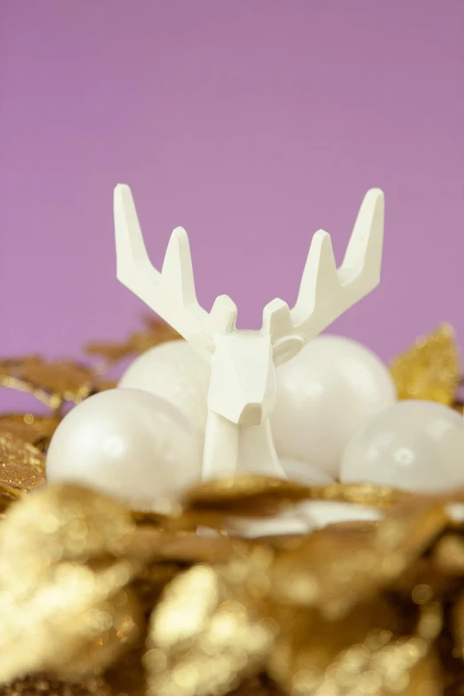 a close up of a cake on a plate, a marble sculpture, inspired by Rudolph F. Ingerle, white pearlescent, gold wings on head, 3 d print, little