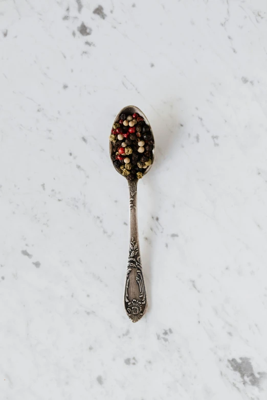 a close up of a spoon on a table, pepper, detailed product image, portrait n - 9, petite