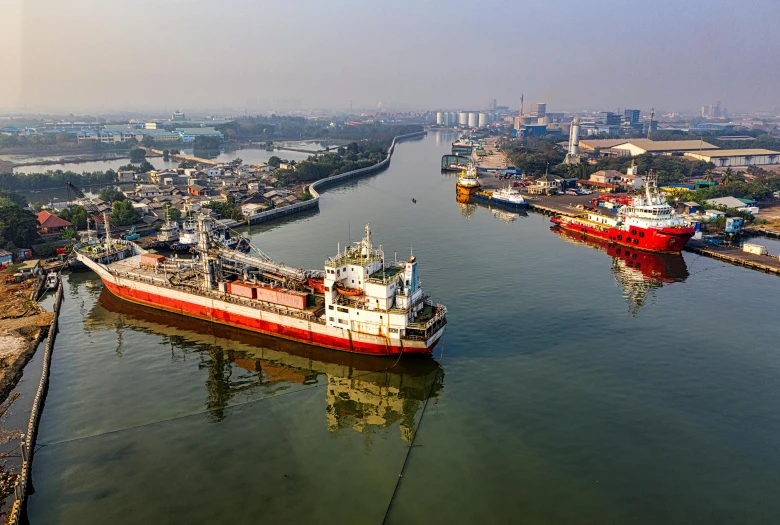 two ships in a body of water with a city in the background, jakarta, industries, thumbnail, aerial view