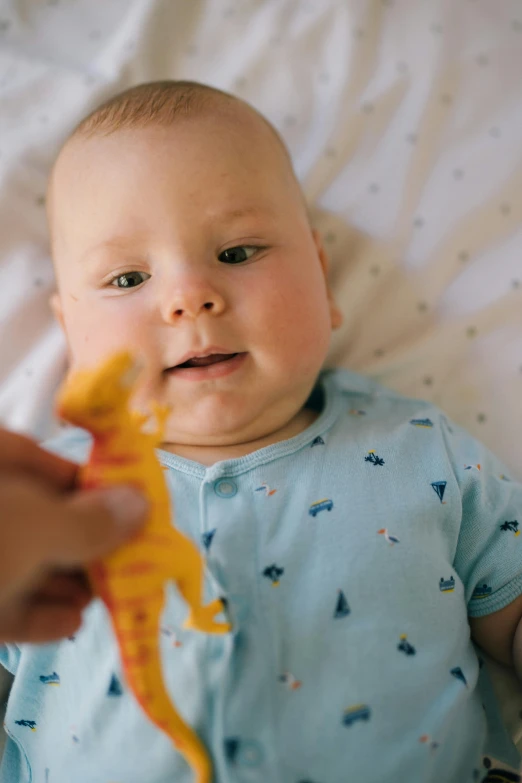 a close up of a person holding a toy, a picture, looking the camera