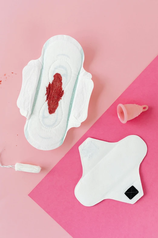 a pair of sanitary pads sitting on top of a pink surface, by Julia Pishtar, white and blood color scheme, center of picture, detailed product image, woman