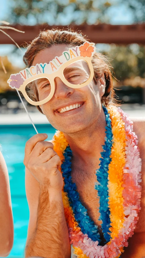 a man and a woman sitting next to a swimming pool, a polaroid photo, pexels, party balloons, joe keery, with navigator shaped glasses, multi - coloured