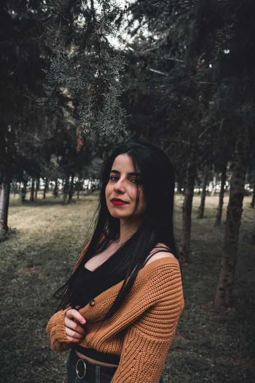 a woman standing in the middle of a forest, inspired by Elsa Bleda, pexels contest winner, realism, 🤤 girl portrait, dark hair, in a city park, wearing a dark sweater