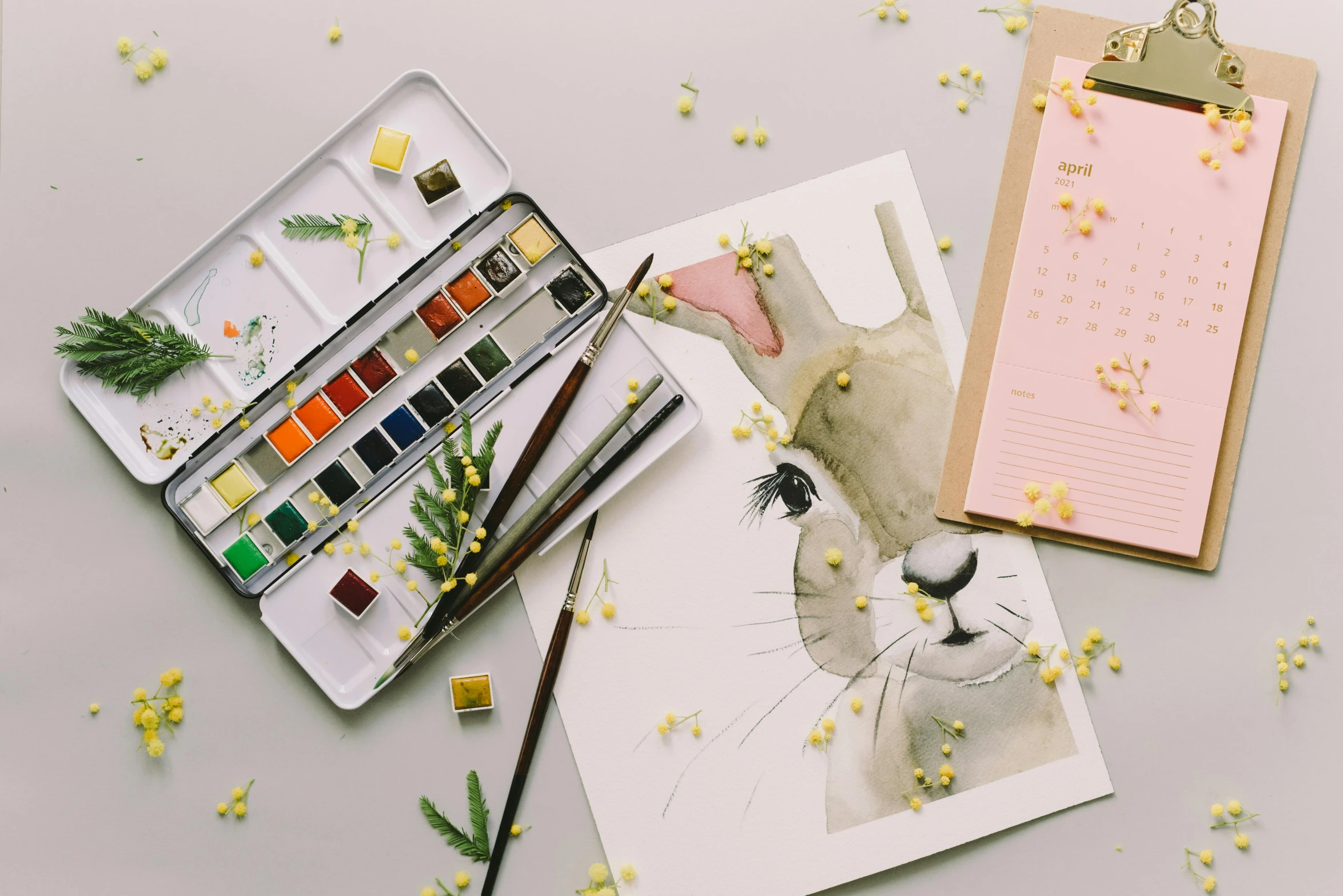 a painting of a rabbit sitting on top of a table, a watercolor painting, trending on pexels, paintbrush and palettes, flatlay, educational supplies, animation still